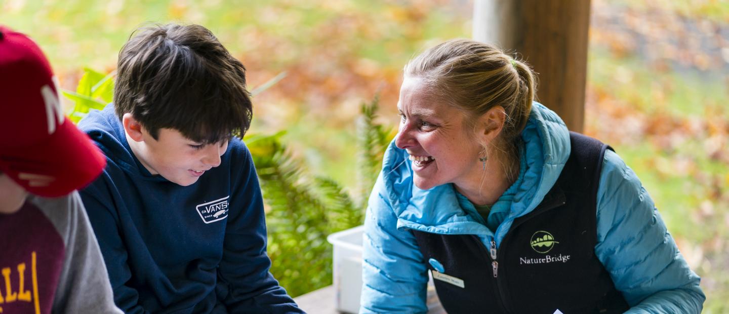 A NatureBridge educator laughs with a student in Olympic National Park