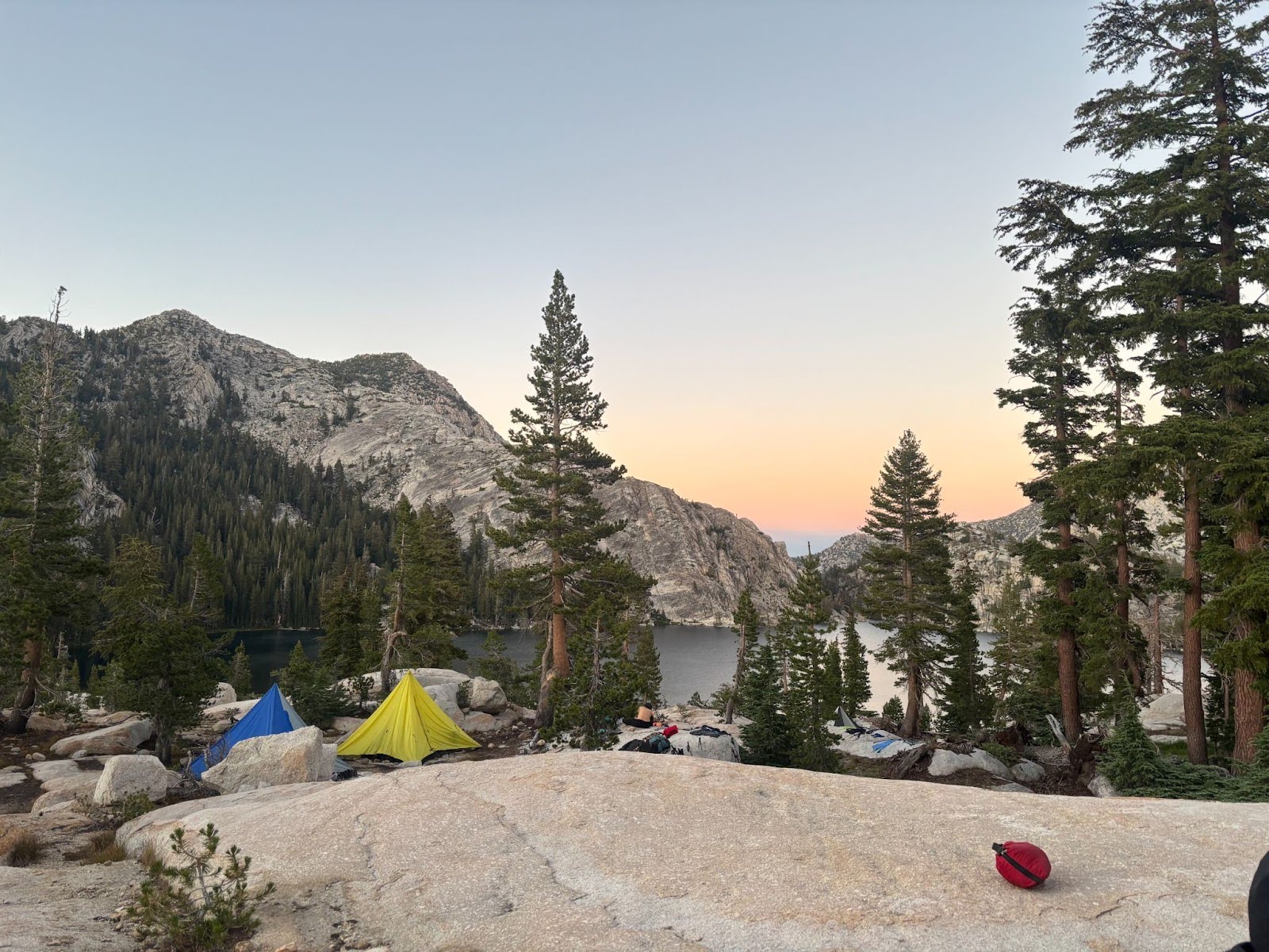 Colorful tents pitched along the shores of an alpine lake