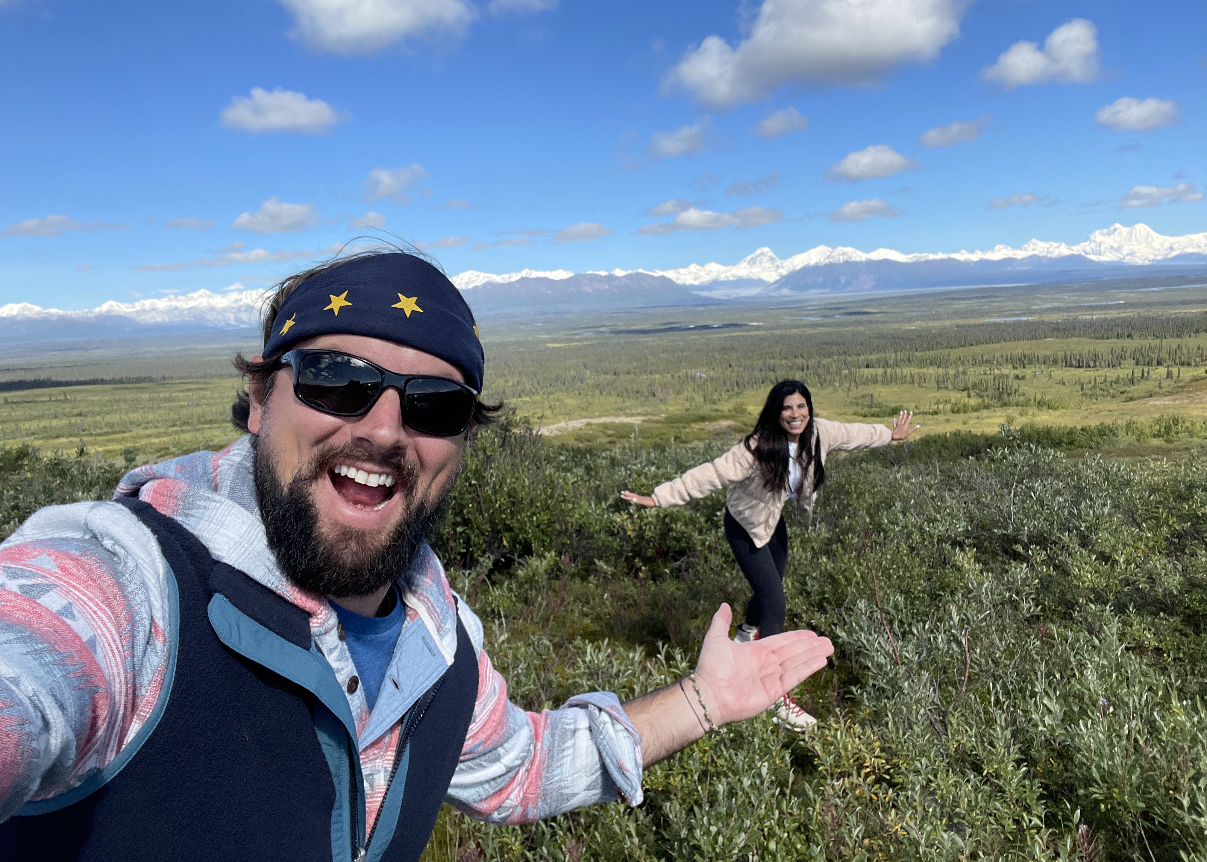 Luke and Laura in a large green meadow in Alaska