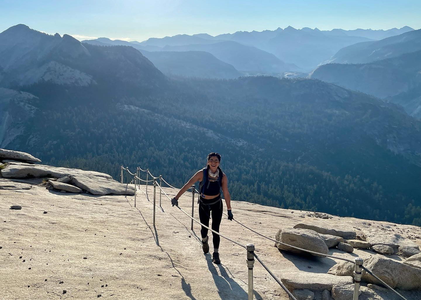 Laura holding on to the metal cables as she hikes up the granite face of Half Dome