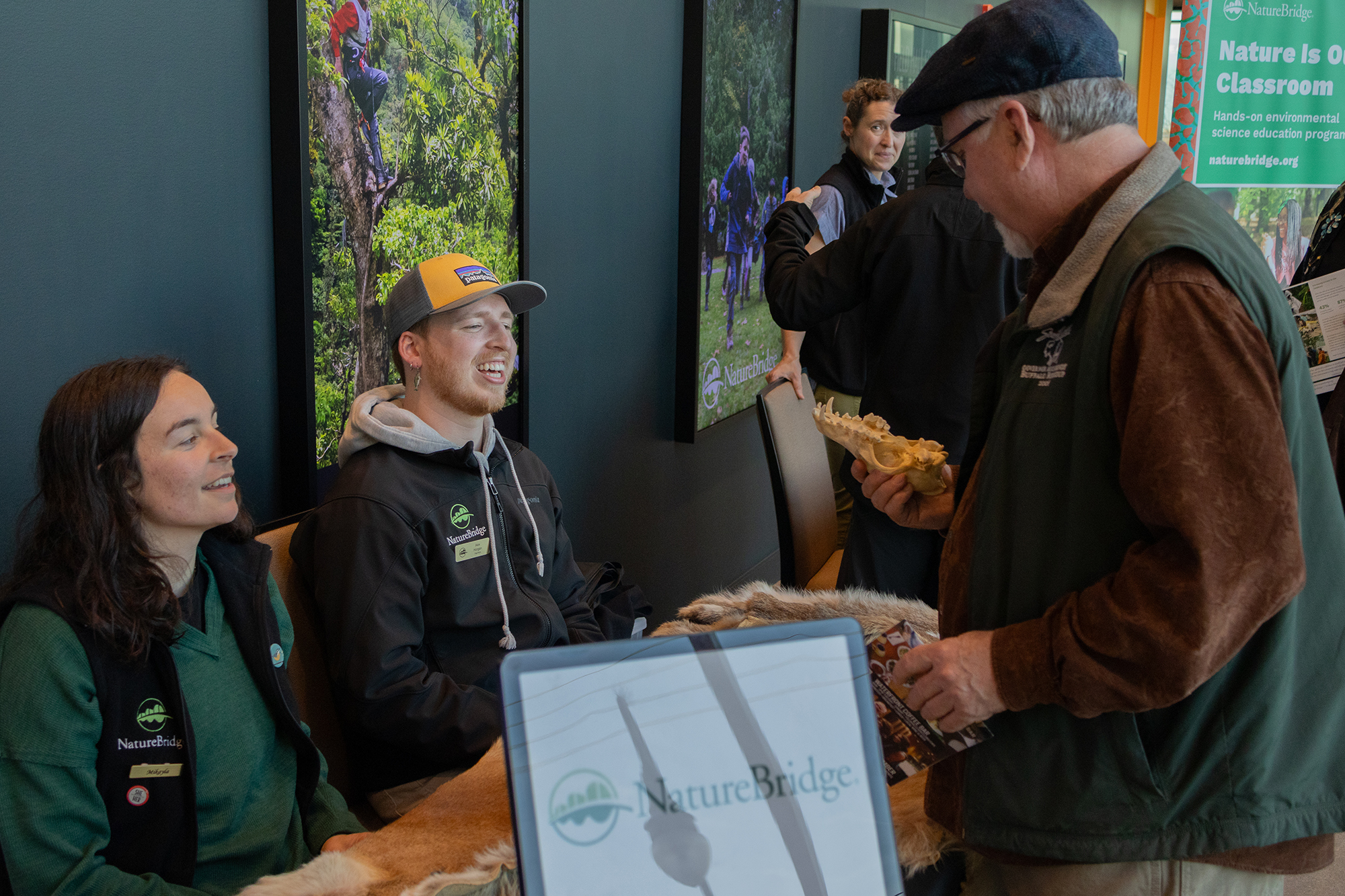 NatureBridge staff talking with an event attendee at the skins and skulls table