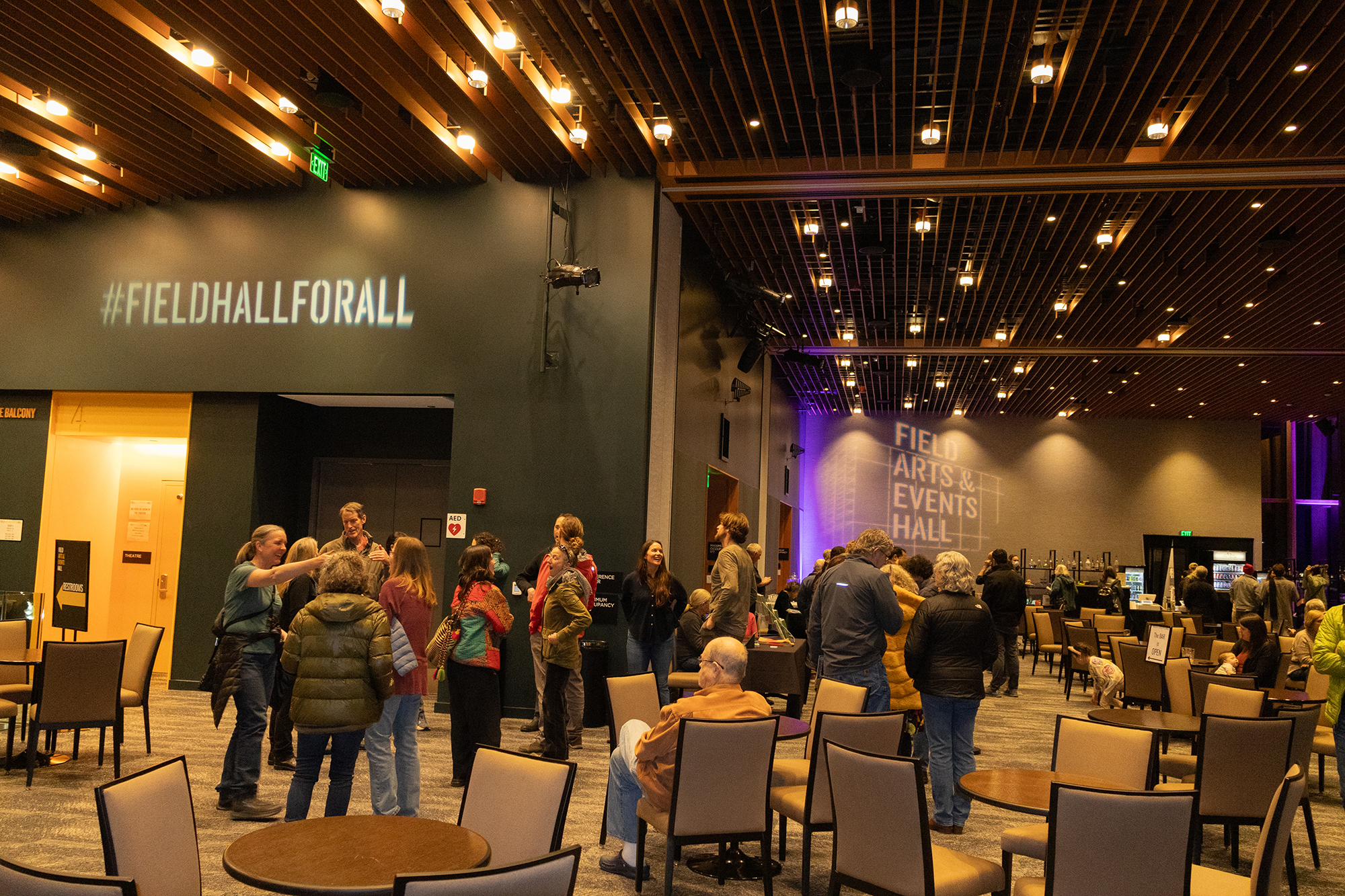 Wide angle view of attendees mingling in the Field Hall lobby