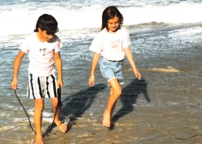 Laura and Lizzy as children walking barefoot in the surf at Rodeo Beach at NatureBridge Golden Gate