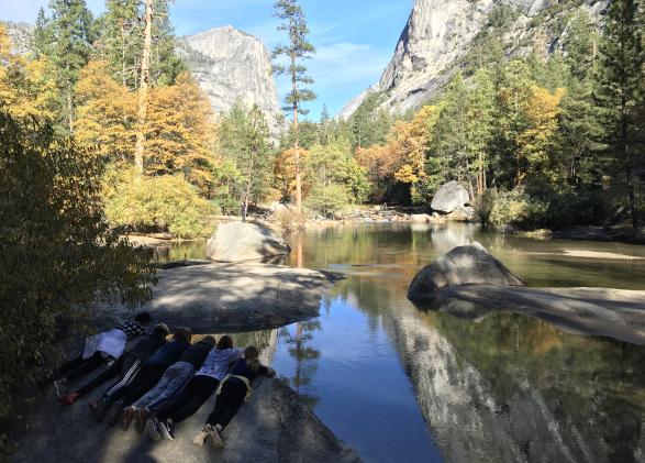 Kids look at their reflection in a lake at NatureBridge's Yosemite campus