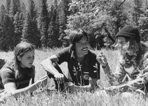 black and white in the grass three people sitting