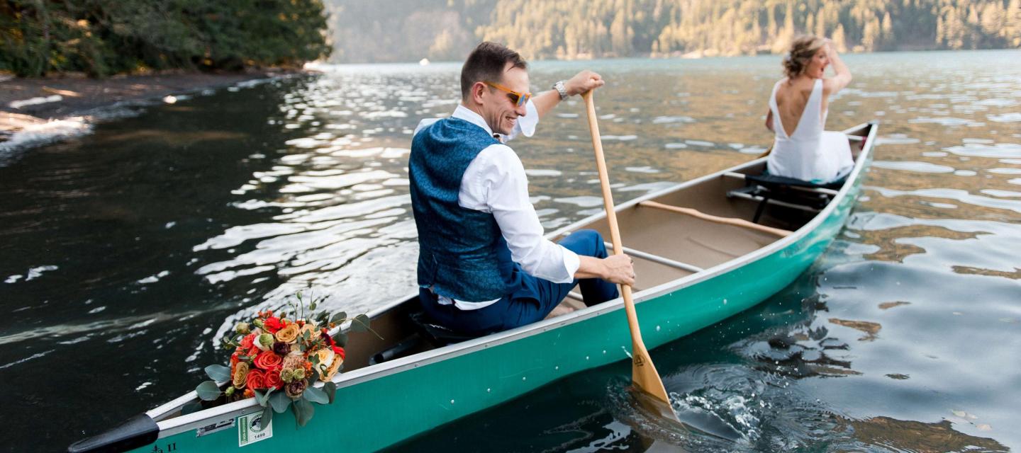Bride and groom rowing a canoe on Lake Crescent