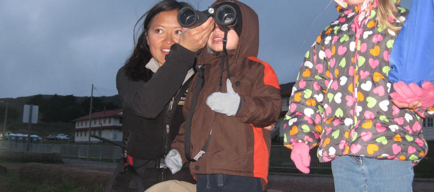 Learning how to use binoculars on a family night hike