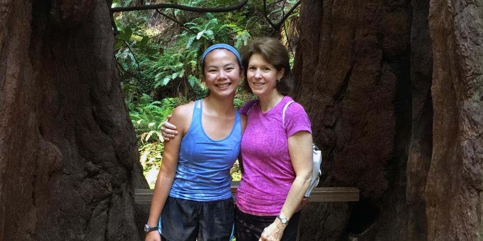 board member Catherine Scott hiking with daughter in the sunny woods