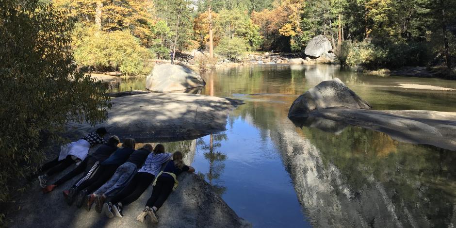 Kids look at their reflection in a lake at NatureBridge's Yosemite campus
