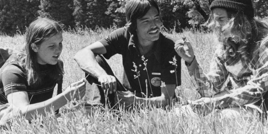 black and white in the grass three people sitting